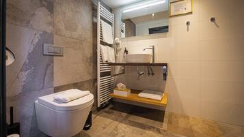 Un baño moderno con inodoro, lavabo y zona de ducha.