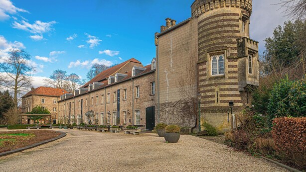 A historic building with a courtyard, stone walls, and a round tower. - Buitenplaats Kasteel Elsloo (Elsloo)
