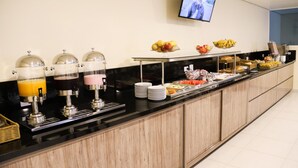 Una mesa de buffet con diversas opciones de comida y una estación de bebidas.