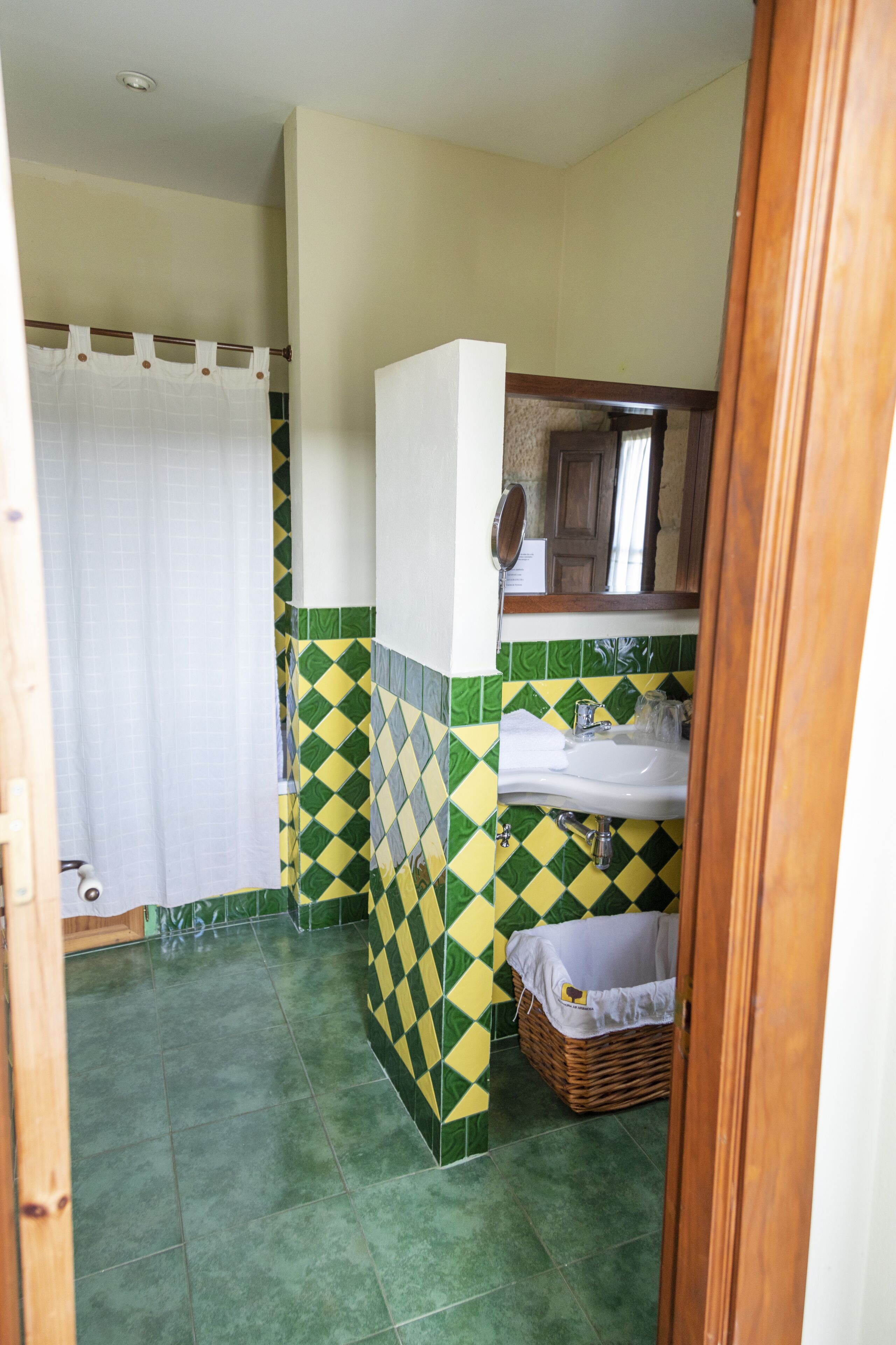 A bathroom with a shower, a sink, and a mirror.