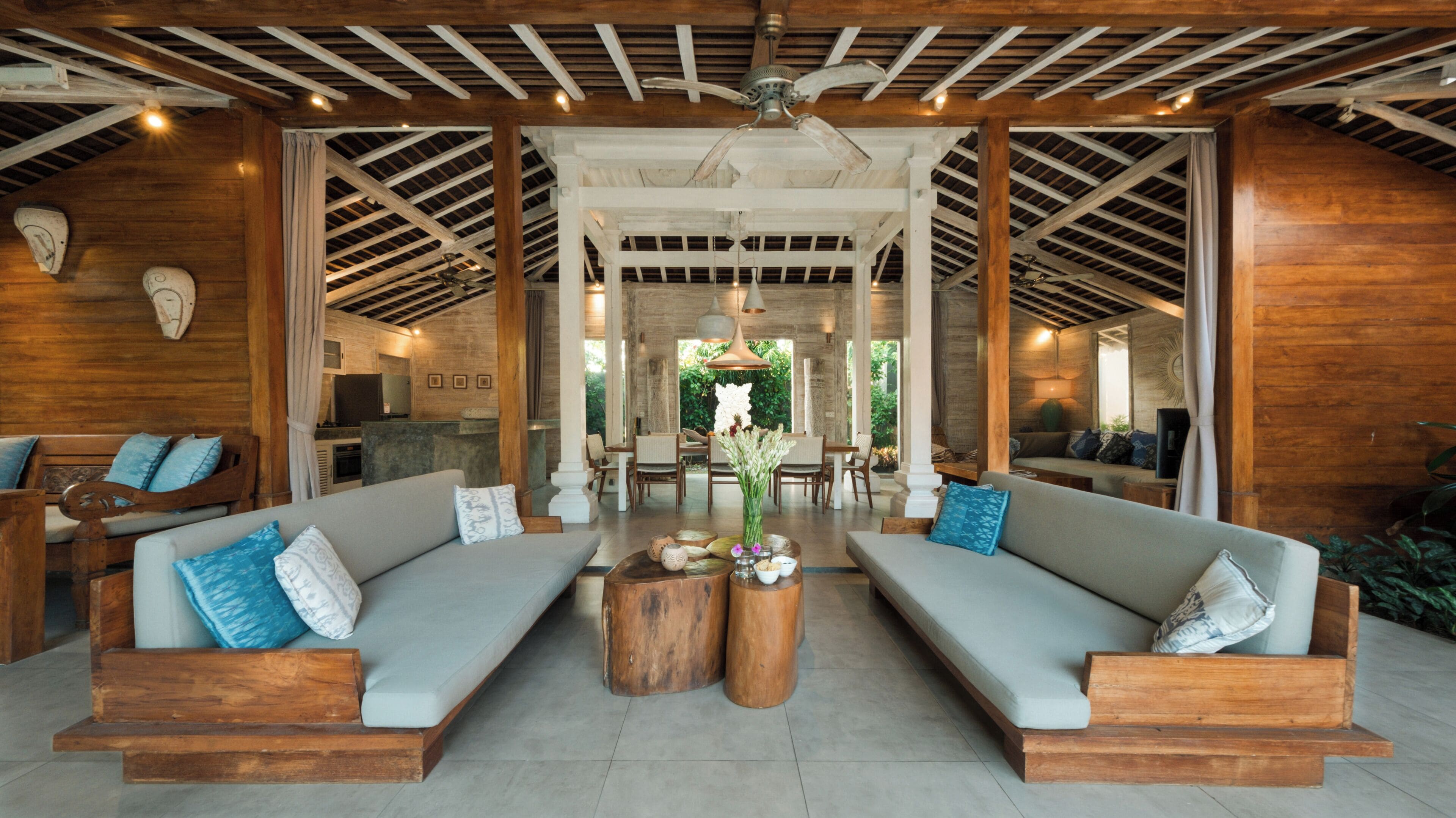 A spacious lounge area with two sofas, a coffee table, and a ceiling fan.