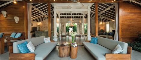 A spacious lounge area with two sofas, a coffee table, and a ceiling fan.