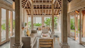 A spacious room with a high ceiling, large windows, and a wooden ceiling structure. - Villa Du Ho by Villa Finder (Kerobokan)