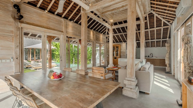 A spacious room with a wooden ceiling, large windows, and a dining area with a table and chairs. - Villa Du Ho by Villa Finder (Kerobokan)