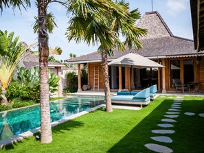 Een buitenzwembad, parasols voor strand/zwembad