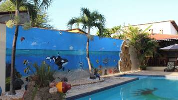 Una piscina al aire libre, sillones reclinables de piscina