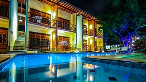 A hotel with a swimming pool, multiple balconies, and a well-lit exterior. - Hotel Pousada Sol & Lua (Paracuru)