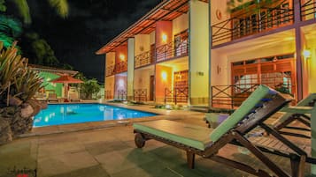 Una piscina al aire libre, sillones reclinables de piscina