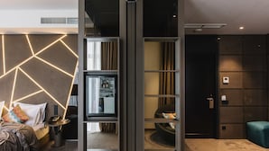 A modern hotel room with a bed, a desk, a television, and a seating area. - Noble Boutique Hotel (Lutsk)