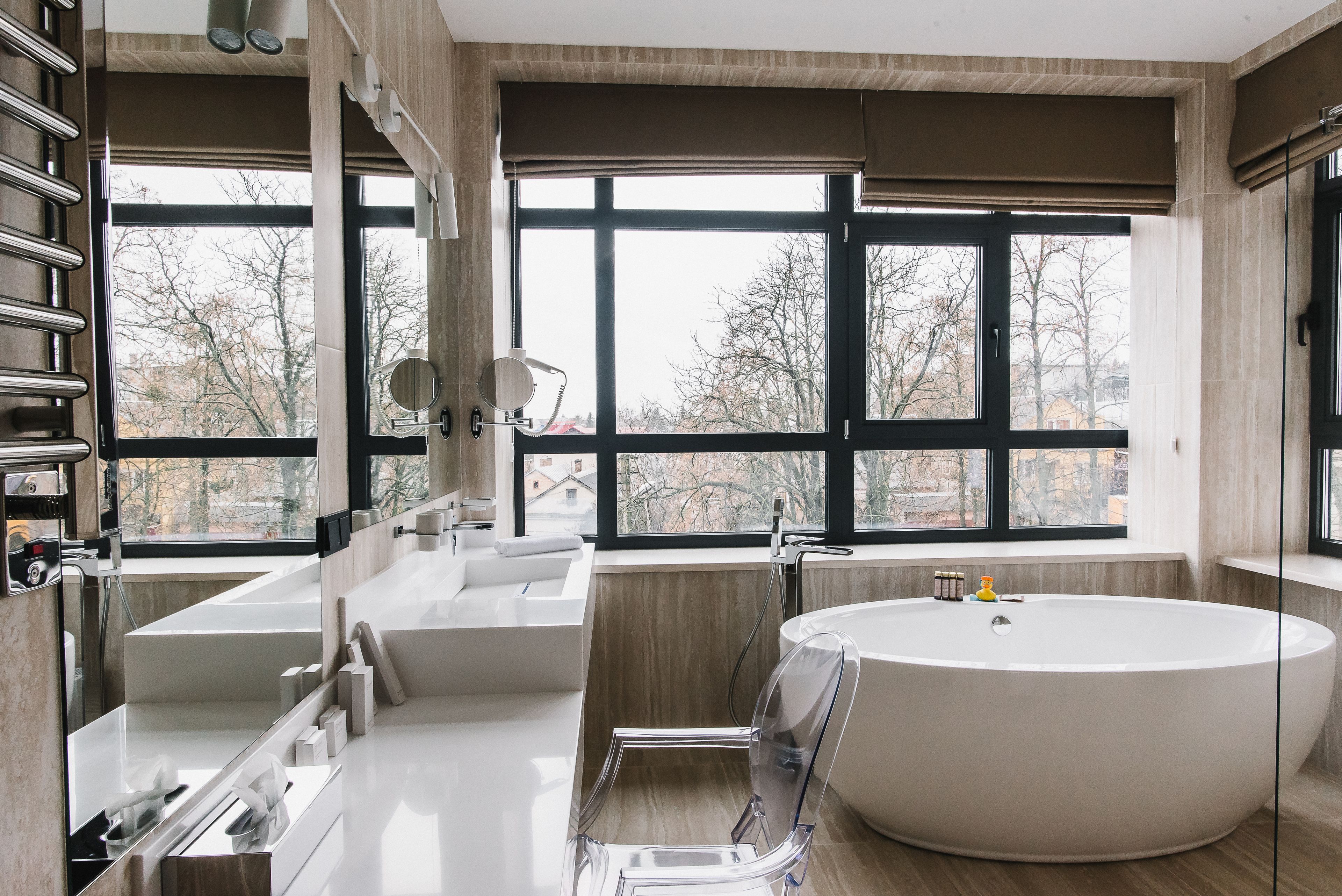 A modern bathroom with a large bathtub, a separate shower area, and a vanity with a mirror.