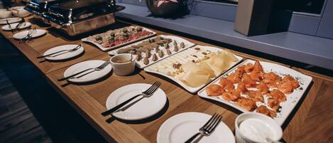 A buffet table with various dishes and utensils.