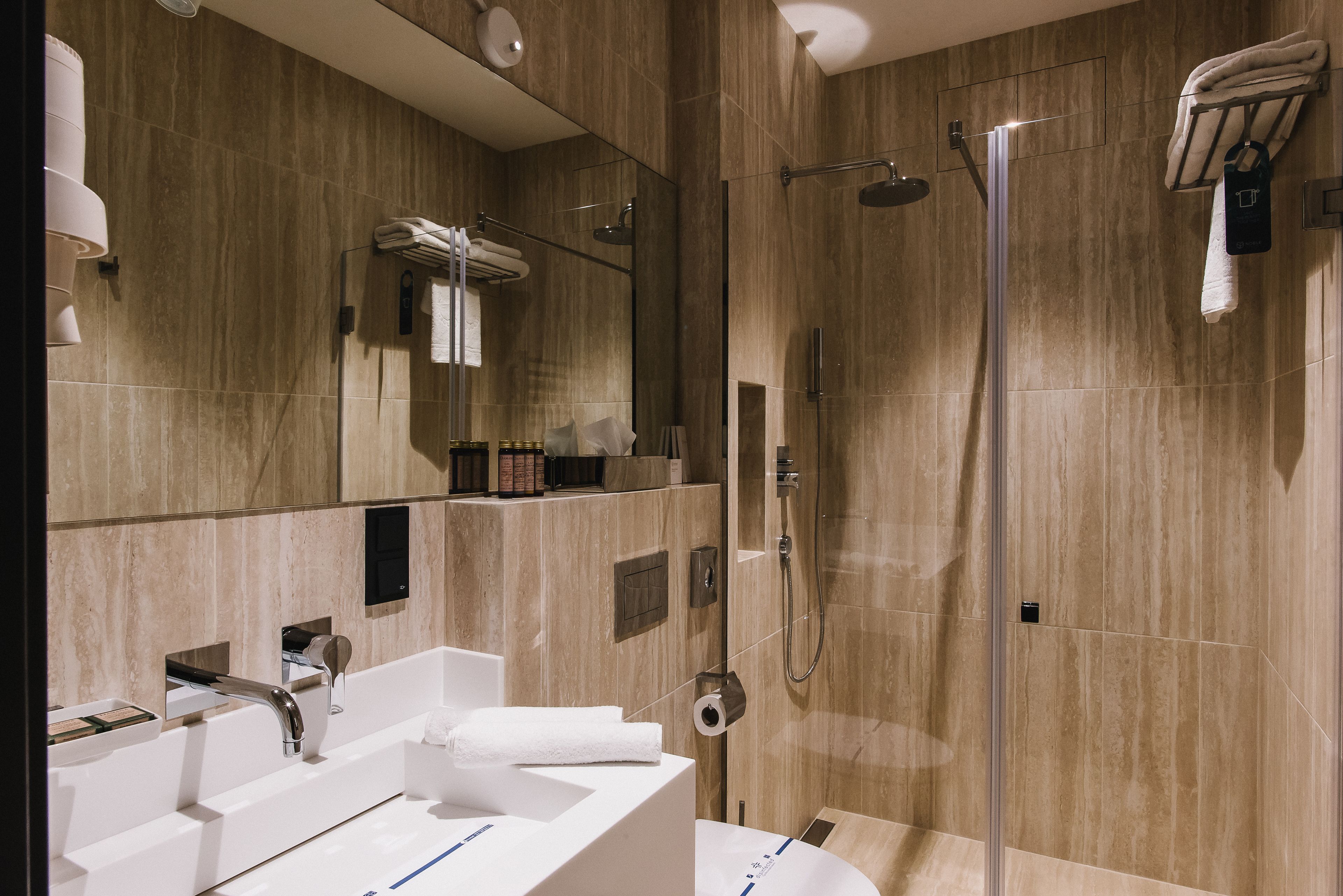 Un baño moderno con un espejo grande, una bañera, una ducha y un lavamanos.