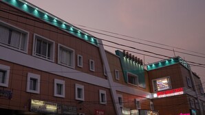 A multi-story building with a sign for "Hotel Embassy Grand" indicating it offers AC rooms and restaurants. - Hotel Embassy International (Muzaffarpur)