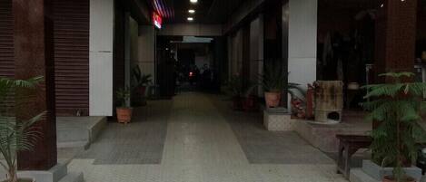 The entrance to Hotel Embassy International with a clear pathway leading to the main entrance.