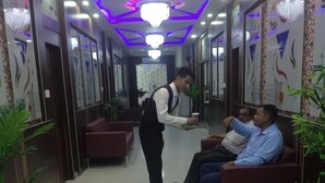 A hotel lobby with a modern design, featuring a reception area, seating arrangements, and decorative elements. - Hotel Embassy International (Muzaffarpur)
