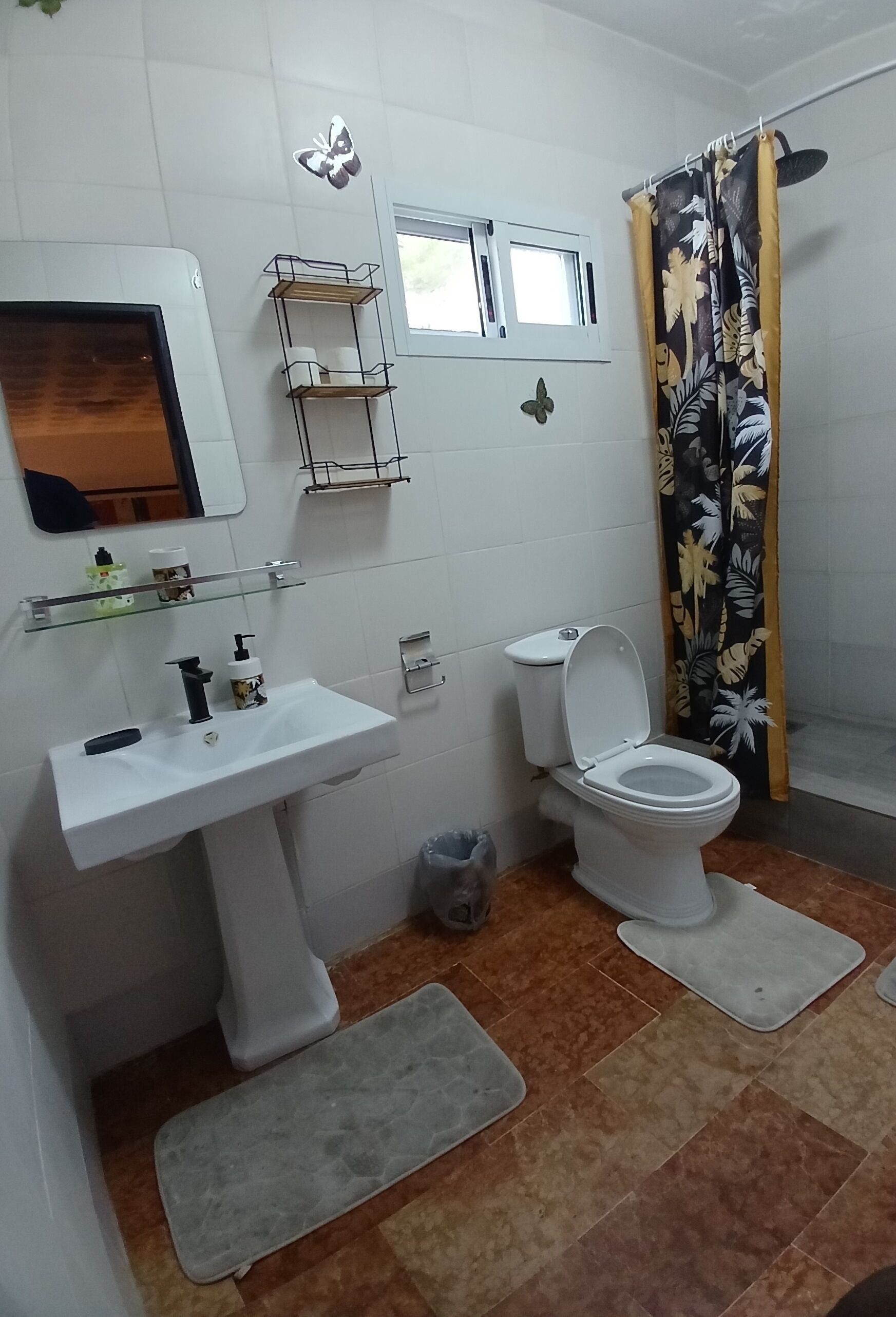 Een badkamer met toilet, wastafel en douchegordijn.