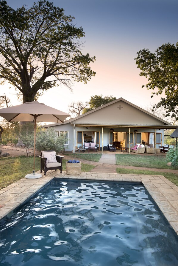 Una piscina al aire libre, sombrillas