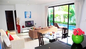 A modern living room with a sofa, chairs, a dining table, and a TV. - Intira Villa Rawai 2 bedrooms villa (Rawai)