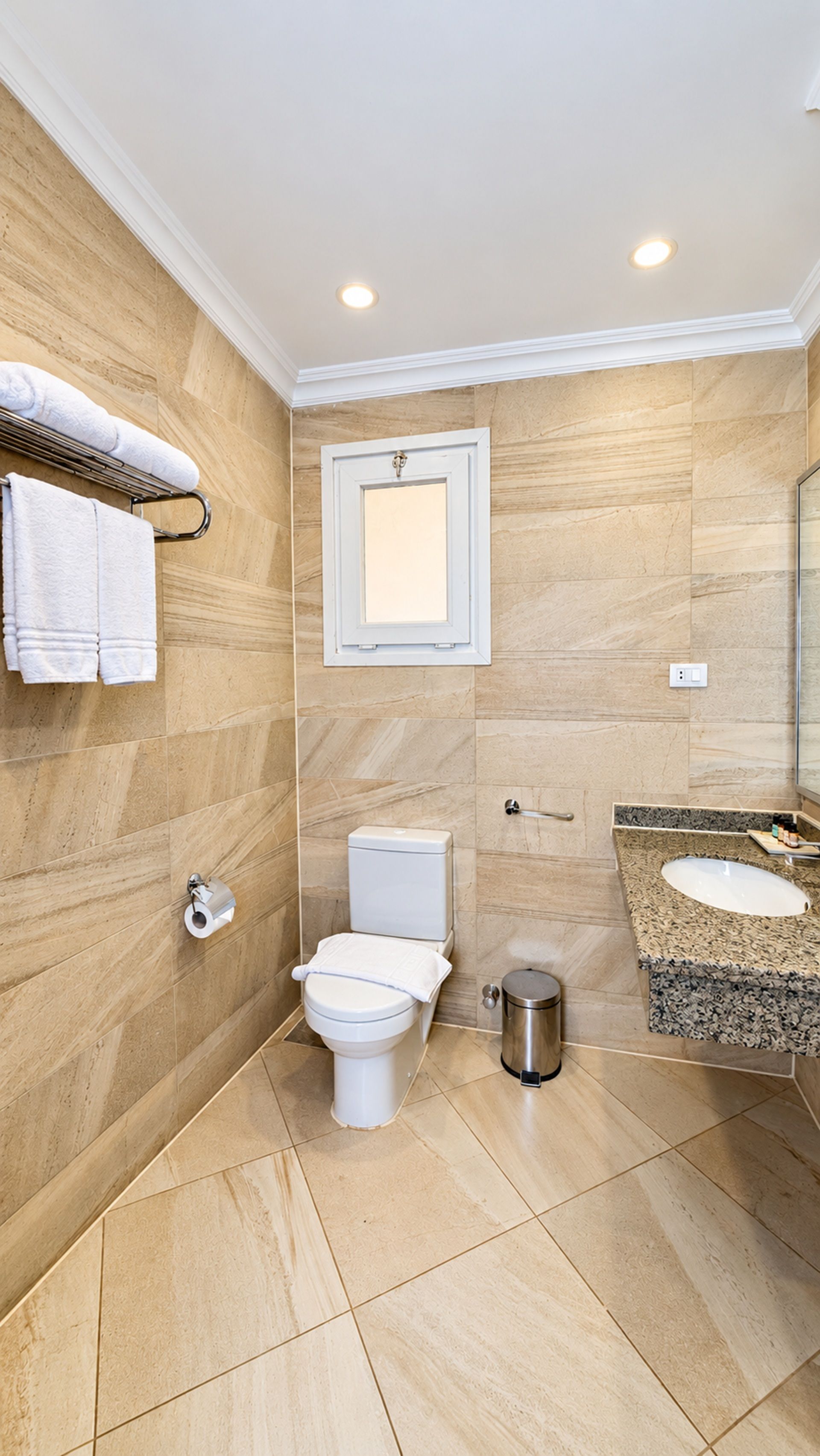 Ein modernes Badezimmer mit Toilette, Waschbecken und Handtuchhalter.