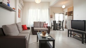 A modern living room with a sofa, coffee table, and TV stand.