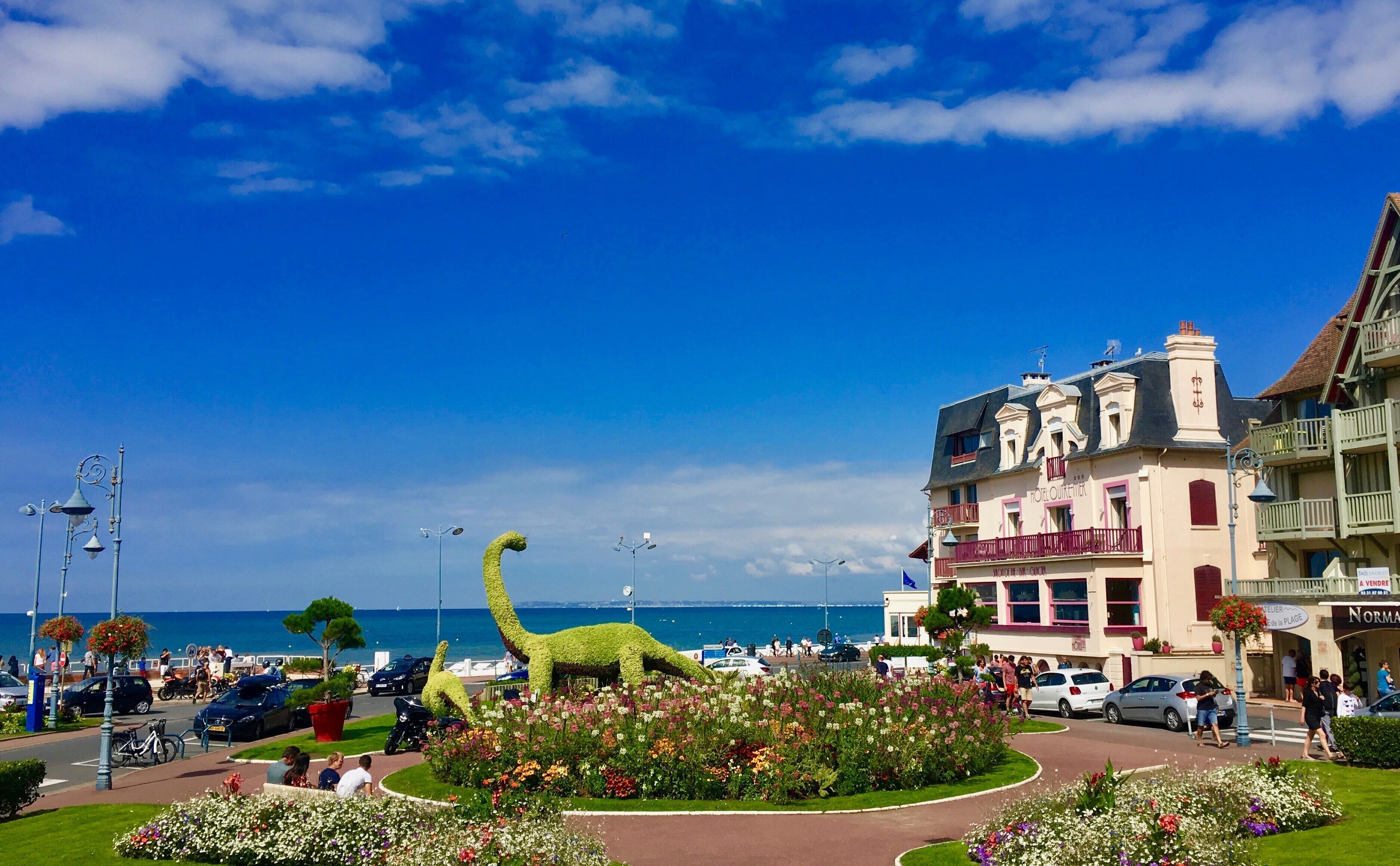 Een hotel in klassieke Europese stijl, met een opvallend balkon en een bord met de tekst te koop.