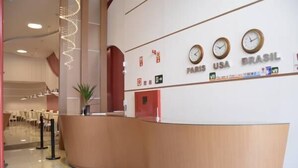 Un comptoir d’accueil avec des horloges indiquant les heures de Paris, des États-Unis et du Brésil.