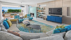 A spacious living room with a large sectional sofa, a coffee table, and a flat-screen TV mounted on the wall. - 52 Victoria (Cape Town)