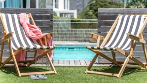 Two striped lounge chairs by a pool with a mountain view in the background. - 52 Victoria (Cape Town)