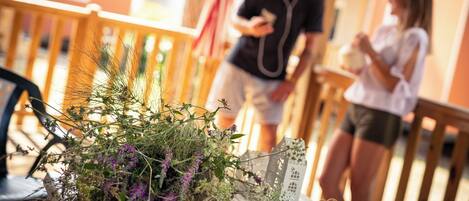 A wooden deck with a railing, a potted plant, and a white lantern.