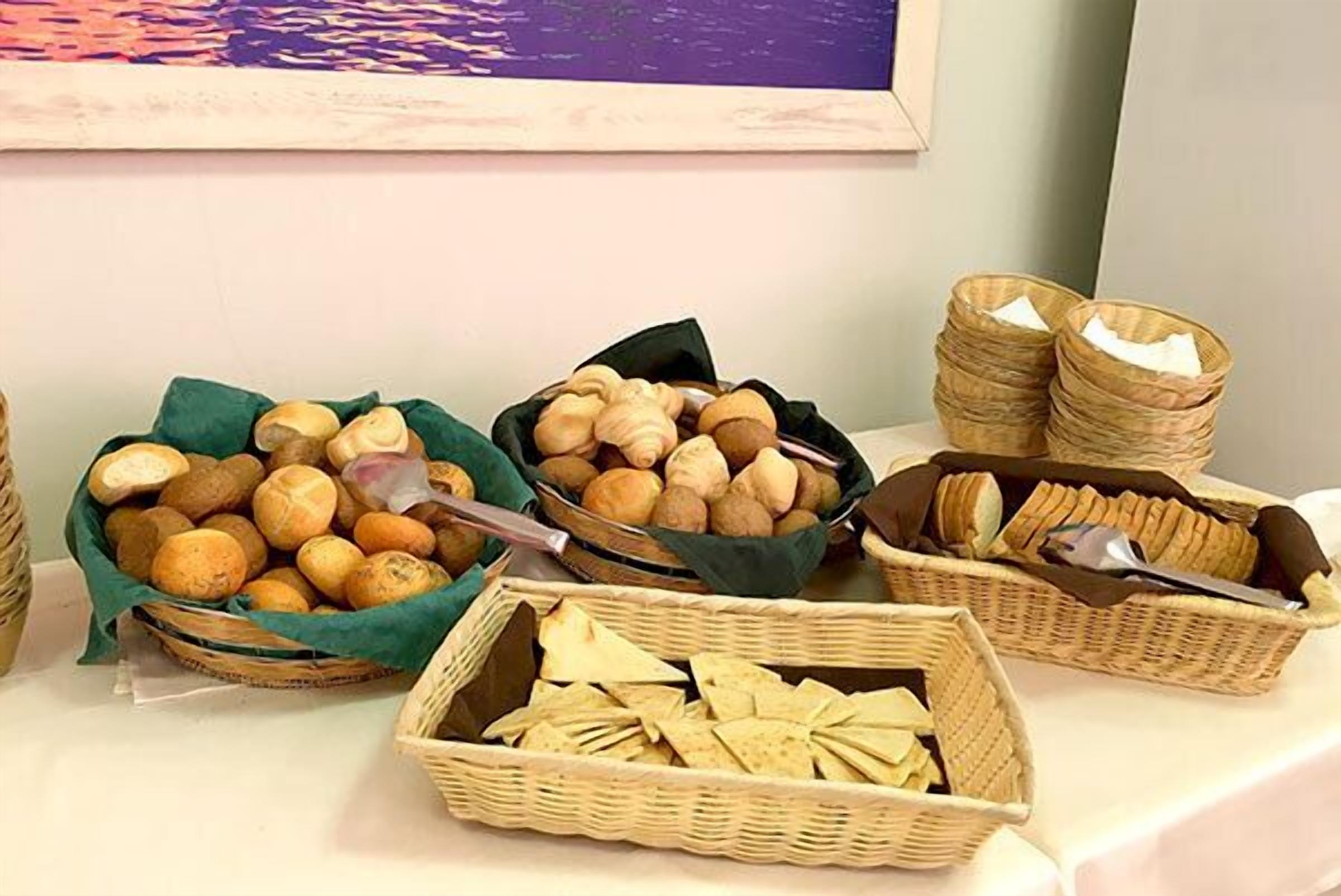 Una mesa con cestas de pan y galletas.