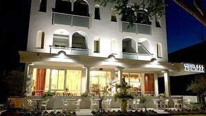 Un hotel de dos pisos con balcón y zona de estar al aire libre.