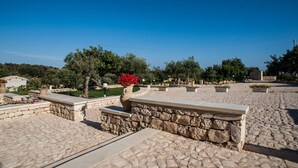 A courtyard with stone pathways, a central seating area, and surrounding greenery. - farmhouse I 5 SENSI (Vr) (modica)