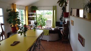 Una cocina amplia con comedor, televisor y diversas plantas.