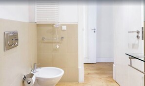 A modern bathroom with a toilet, sink, and shower.