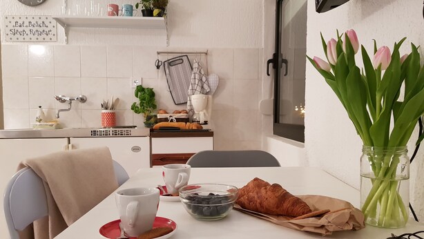 A dining area with a table set for two, featuring a croissant, a bowl of blueberries, and a cup. - Casa Nostra (Funtana)