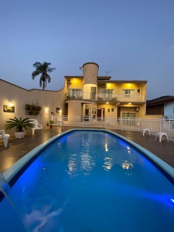 Una piscina al aire libre, sillones reclinables de piscina