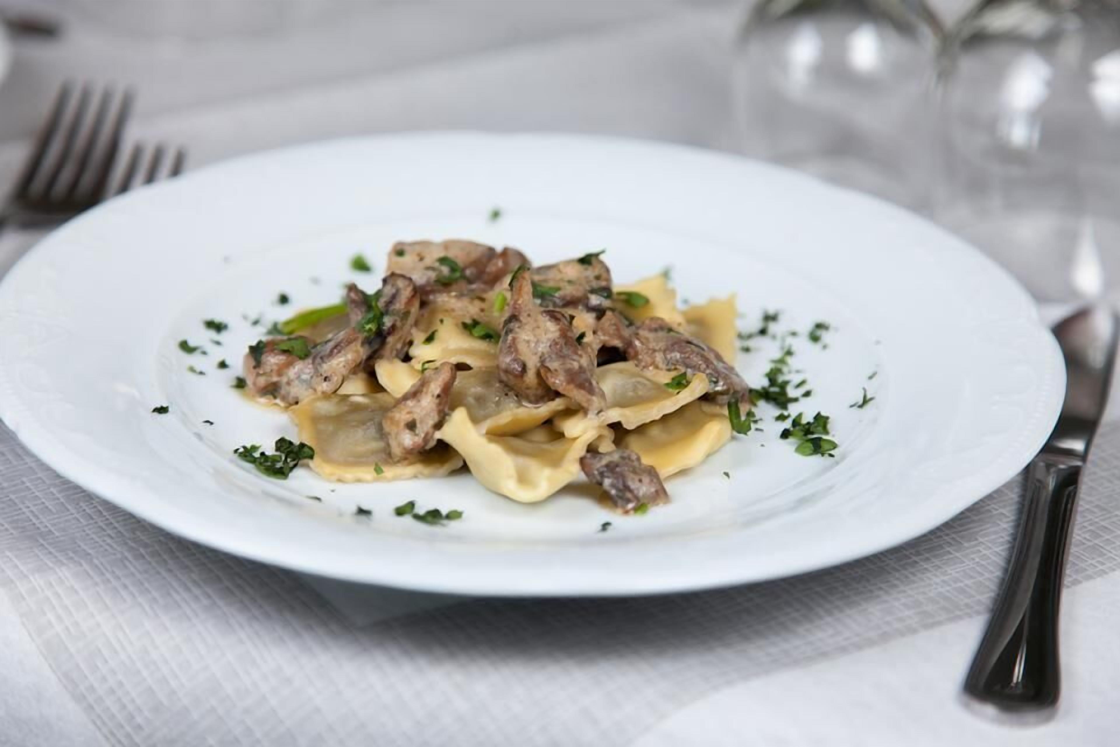 Eine Portion Pasta mit Fleisch und Kräutern.
