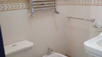 Un baño pequeño con inodoro, bidé y lavabo.