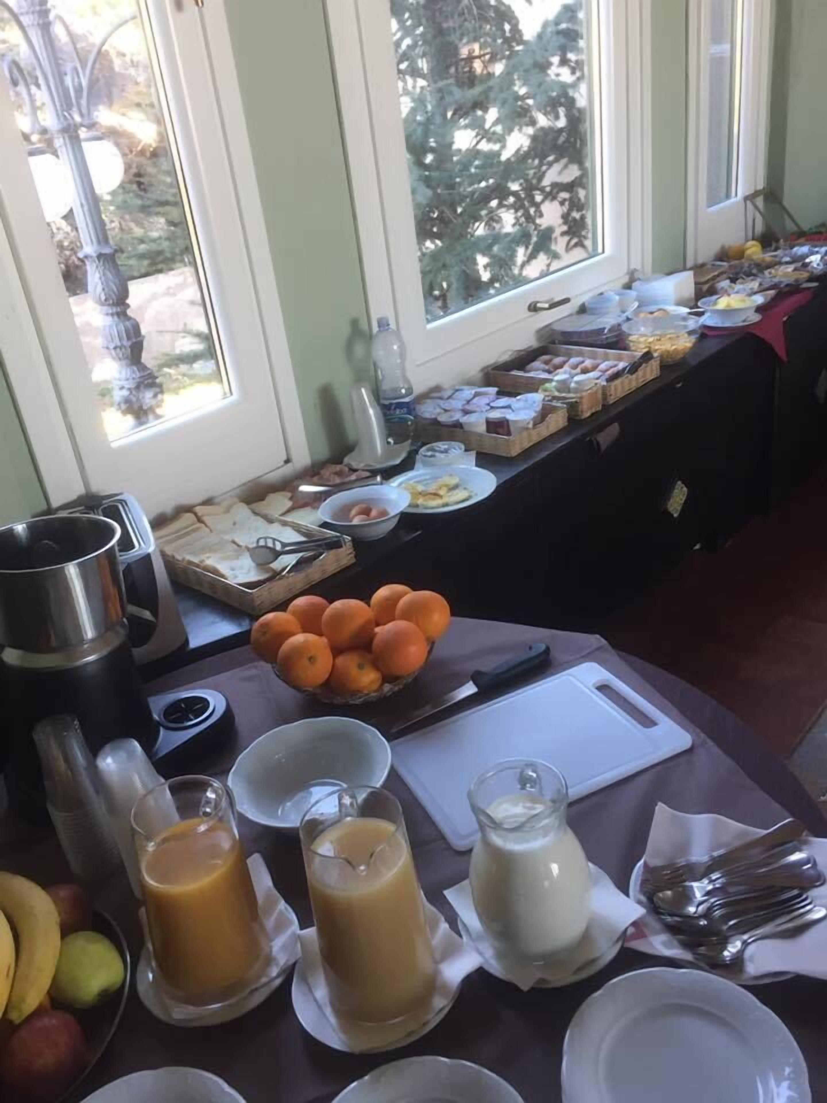 A breakfast buffet with various food items, a fruit bowl, and beverages.