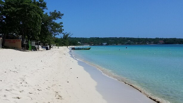 A beach with a sign for 'EGRIL BEACH CLUB'. - Cozy Condo on the Beach (Negril)