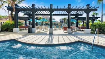 Un espace piscine agrémenté d’une pergola, de chaises longues et de parasols.