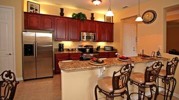 A modern kitchen with a central island, stainless steel appliances, and wooden cabinetry.