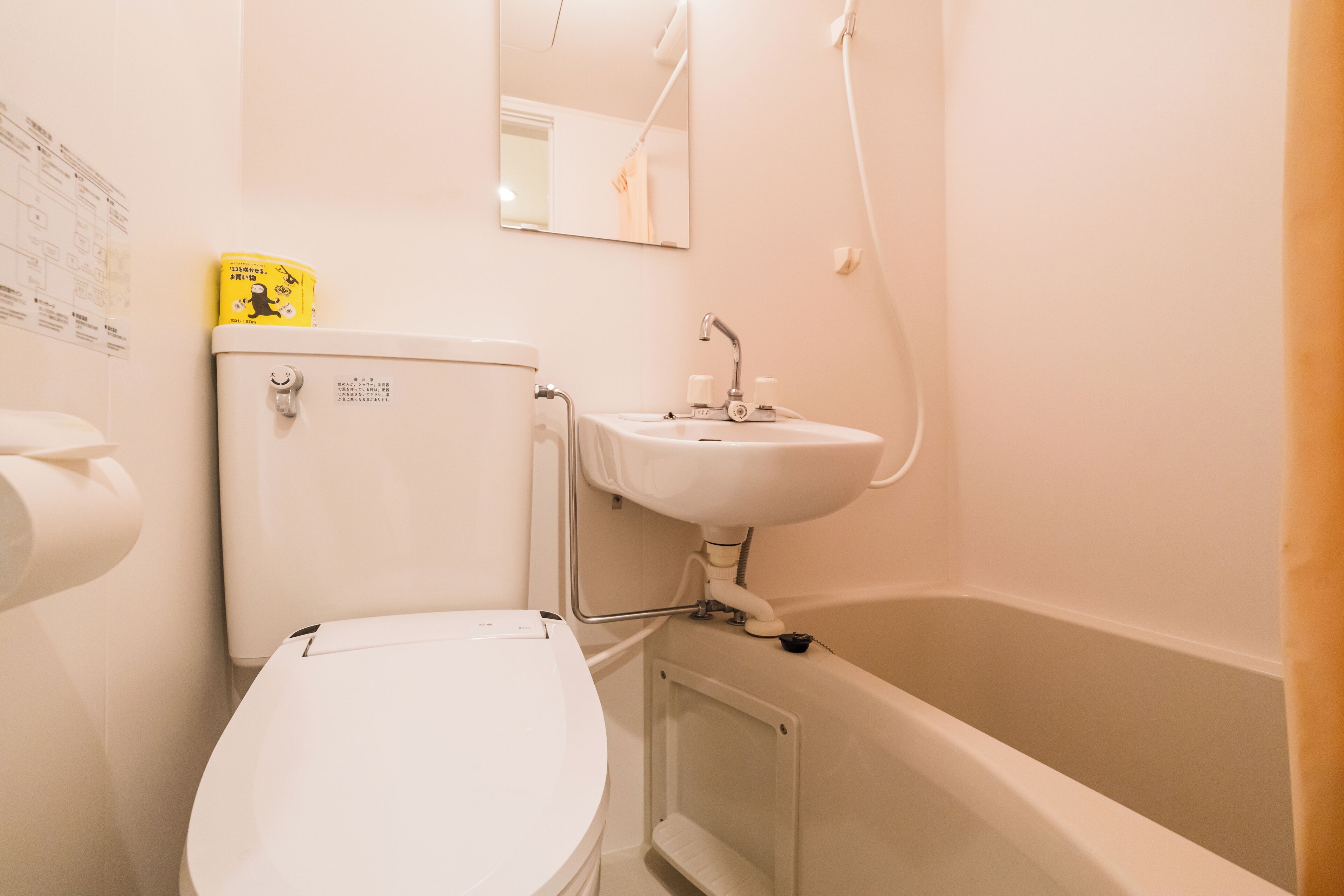 Et badeværelse med toilet, vask og badekar.
