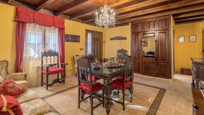 A dining area with a wooden ceiling, a chandelier, and a table set with a decorative centerpiece. -  House Ludima in Fuentes de Andalucia, 40 min from Sevilla and 50 min of Cordoba (Fuentes de Andalucía)