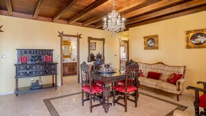 A dining area with a wooden ceiling, chandelier, ornate furniture, and a sofa with red cushions. -  House Ludima in Fuentes de Andalucia, 40 min from Sevilla and 50 min of Cordoba (Fuentes de Andalucía)