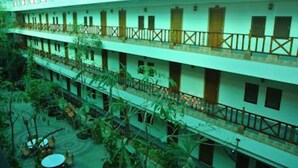 A multi-story building with balconies and a central courtyard with plants. - Chaikanathani Hotel (Phatthalung)