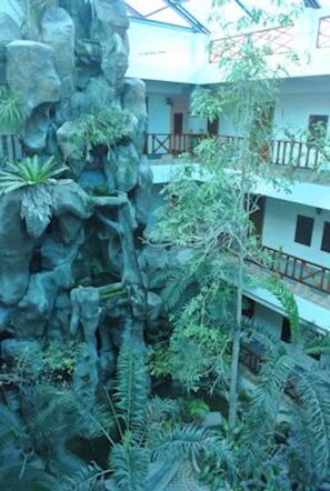 A multi-level building with a rock garden and various plants.