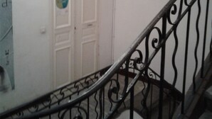Un escalier avec une porte blanche et un panneau circulaire sur le mur.