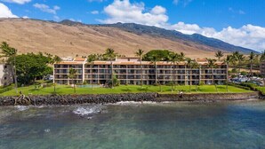 Un hotel con varios pisos, piscina y vistas a las montañas.