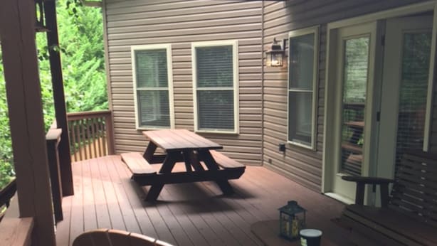 A wooden deck with a picnic table, a wooden chair, and a lantern. - Rumbling Bald Resort/Lake Lure/ Small Fee for Golf Cart.  Low cleaning fees. (Lake Lure)